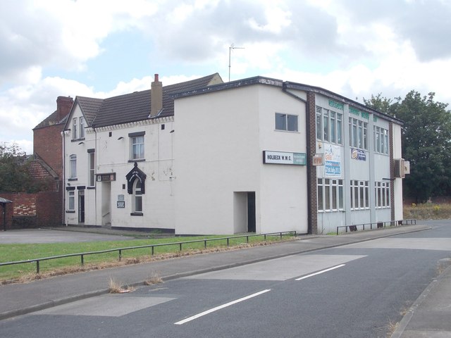 This is an image of the Holbeck working men's club. It is taken from across the road and what is seen is a white building with windows lining the right side.