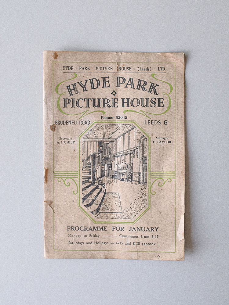 A birdeye shot looking down at the programme against a white background. The programme says Hyde Park Picture House with an illustration of the main foyer. It has green detailing decorating the page and states January.