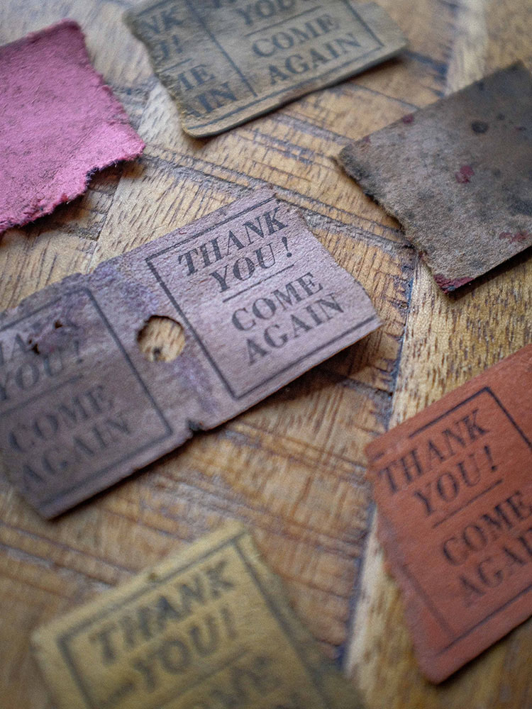 The image is an extreme close up of the ticket stubs. They are organised row by row and feature a variety of bright colours including purple, yellow, red, and pink. They read Thank You! Come again.